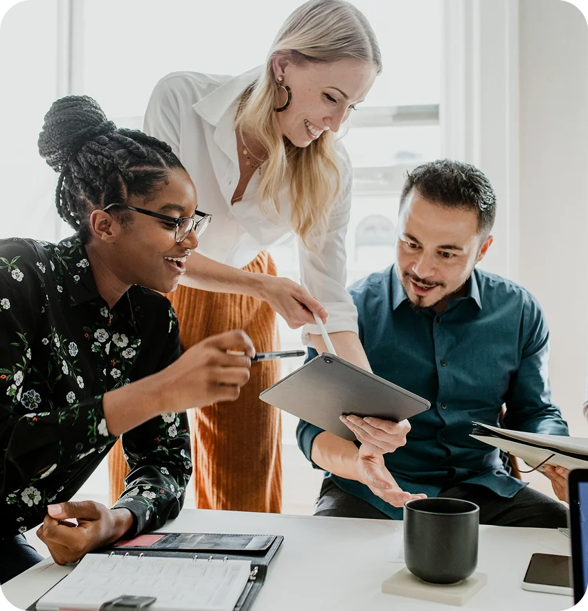 Three colleagues collaborating at a desk.